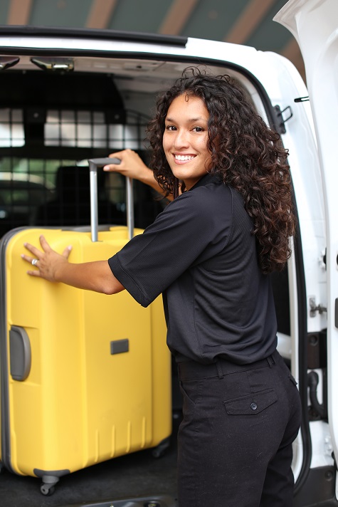 Worker loading a suitcase in car